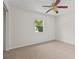 Bedroom with neutral walls, carpet flooring, ceiling fan, and a window overlooking a green space at 4425 Porpoise Dr, Tampa, FL 33617
