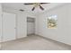 Bedroom featuring a ceiling fan, closet, neutral walls, carpet flooring, and a view of the neighborhood at 4425 Porpoise Dr, Tampa, FL 33617