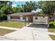 Charming single-story home with a brick accent, carport, and a well-maintained lawn at 4425 Porpoise Dr, Tampa, FL 33617