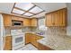 Bright kitchen features wood cabinets, granite countertops, mosaic tile backsplash and modern white appliances at 4425 Porpoise Dr, Tampa, FL 33617