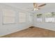 Inviting living room with wood laminate flooring, three windows, and a front door at 4425 Porpoise Dr, Tampa, FL 33617