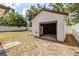 Exterior view of the shed in the backyard featuring a roll up door and adjacent white fence at 4425 Porpoise Dr, Tampa, FL 33617