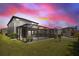 A backyard screened patio with comfortable outdoor seating amidst lush landscaping at 4679 Emprise Way, Land O Lakes, FL 34638