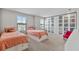 Bright bedroom featuring two twin beds and ample storage with frosted-glass-door wardrobes at 4679 Emprise Way, Land O Lakes, FL 34638