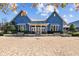 Charming blue clubhouse with brick entryway, offering a welcoming space for community events and resident gatherings at 4679 Emprise Way, Land O Lakes, FL 34638