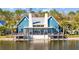 Beautiful blue clubhouse with waterfront deck, perfect for relaxing by the water and enjoying community amenities at 4679 Emprise Way, Land O Lakes, FL 34638
