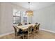 Dining room with decorative light fixture, wood table, and black chairs at 4679 Emprise Way, Land O Lakes, FL 34638