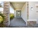 Inviting entryway features stone accents, a decorative glass door, neutral siding, and a brick-paver landing at 4679 Emprise Way, Land O Lakes, FL 34638