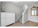 Bright entryway with wood-look flooring, staircase, decorative mirror, and white cabinet storage at 4679 Emprise Way, Land O Lakes, FL 34638
