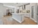 Open-concept kitchen features a center island, dining area, stainless appliances, white cabinetry, and tile backsplash at 4679 Emprise Way, Land O Lakes, FL 34638