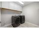 Well-equipped laundry room with front load washer and dryer and storage cabinets at 4679 Emprise Way, Land O Lakes, FL 34638