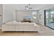Bright living room features a large white couch, wood-look floors, and sliding glass doors to the lanai at 4679 Emprise Way, Land O Lakes, FL 34638