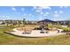 Community playground with a covered play structure and picnic benches against a backdrop of neighborhood homes at 4679 Emprise Way, Land O Lakes, FL 34638