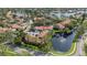 An aerial view of a lovely neighborhood with terra cotta roofs near a pond, highlighted by beautiful mature trees at 4783 Palermo Ne Ct # 4783, St Petersburg, FL 33703