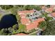 An aerial view of a quaint community showcasing terra cotta roofs, pond views, and mature landscaping at 4783 Palermo Ne Ct # 4783, St Petersburg, FL 33703