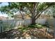 Private backyard featuring shade tree, partial privacy fence, stone landscaping, and view of neighboring building at 4783 Palermo Ne Ct # 4783, St Petersburg, FL 33703
