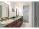 Bathroom featuring double sinks, elegant mirrors, a green countertop, and a glass door shower at 4783 Palermo Ne Ct # 4783, St Petersburg, FL 33703