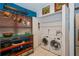 A conveniently located laundry room features modern washer and dryer, and ample storage with a hanging pot rack above at 4783 Palermo Ne Ct # 4783, St Petersburg, FL 33703
