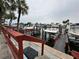 View of the community boat dock, including one boat moored in the water and palm trees at 4851 W Gandy Blvd # B1L8, Tampa, FL 33611
