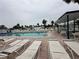 Picture of the community pool with lounge chairs on the brick patio and tables under a covered area at 4851 W Gandy Blvd # B1L8, Tampa, FL 33611