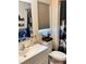 Bathroom with a single sink vanity, stylish mirror, and a toilet accented with unique decor and accessories at 5351 Leisure Ln, New Port Richey, FL 34652
