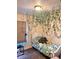 Charming bedroom with unique leaf vines hanging from the ceiling, large window, and soft carpet at 5351 Leisure Ln, New Port Richey, FL 34652