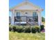 Charming home exterior showcasing a welcoming front porch, complemented by lush greenery and a tidy lawn at 5351 Leisure Ln, New Port Richey, FL 34652
