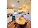 Bright kitchen featuring white cabinets, stainless appliances, a breakfast nook, and wood look vinyl flooring at 5351 Leisure Ln, New Port Richey, FL 34652