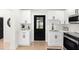Modern kitchen design with white cabinets and stainless appliances and a black entry door at 621 89Th N Ave, St Petersburg, FL 33702