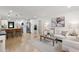 Open-concept living room with modern decor, wood floors, kitchen access, and abundant natural light at 621 89Th N Ave, St Petersburg, FL 33702