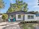 Charming single-story home with a brick accent wall, blue front door and well-manicured landscaping at 6738 Criswell N Ave, St Petersburg, FL 33709