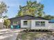 Charming home with a two-tone exterior, lovely landscaping, and inviting outdoor seating at 6738 Criswell N Ave, St Petersburg, FL 33709