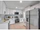 Bright kitchen with white cabinets, stainless steel appliances, quartz countertops and hardwood floors at 6738 Criswell N Ave, St Petersburg, FL 33709