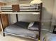 A bunkbed with gray linens, and a top bunk safety rail. Next to closet for storage at 701 S Madison Ave # 515, Clearwater, FL 33756