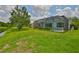 Lush green backyard with a screened-in lanai overlooking a peaceful pond, perfect for relaxation at 7114 Cromwell Park Ln, Apollo Beach, FL 33572