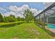 Spacious backyard with a screened-in lanai overlooking a tranquil pond and lush green landscaping at 7114 Cromwell Park Ln, Apollo Beach, FL 33572