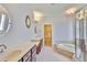 Bright bathroom featuring double sinks, soaking tub, and separate glass-enclosed shower at 7114 Cromwell Park Ln, Apollo Beach, FL 33572
