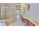 Bright bathroom featuring a shower, bathtub, double sinks and tile flooring at 7114 Cromwell Park Ln, Apollo Beach, FL 33572