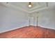 Bedroom featuring hardwood floors, ceiling fan, and adjacent bathroom access at 7114 Cromwell Park Ln, Apollo Beach, FL 33572
