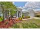Well-maintained home exterior with lush landscaping, a two-car garage, and lovely curb appeal at 7114 Cromwell Park Ln, Apollo Beach, FL 33572