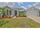 Charming home featuring a three-car garage, beautiful landscaping, and a welcoming entrance at 7114 Cromwell Park Ln, Apollo Beach, FL 33572