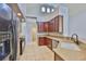 Kitchen with stainless steel appliances, tiled floors, and a corner sink at 7114 Cromwell Park Ln, Apollo Beach, FL 33572