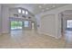 Bright living room with tile floors, vaulted ceilings, and sliding glass doors to the outdoor pool at 7114 Cromwell Park Ln, Apollo Beach, FL 33572