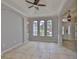 Inviting living room with tiled floors, three arched windows, and an elegant chandelier at 7114 Cromwell Park Ln, Apollo Beach, FL 33572