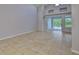 Open living room featuring neutral walls, tile floors, and sliding glass doors to the lanai at 7114 Cromwell Park Ln, Apollo Beach, FL 33572