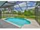 Inviting screened-in pool with clear blue water surrounded by a patio and lush green landscaping at 7114 Cromwell Park Ln, Apollo Beach, FL 33572
