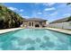 Backyard pool and patio area featuring travertine tile, manicured landscaping, and an inviting view of the home at 719 58Th S St, Gulfport, FL 33707