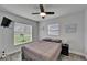 Comfortable bedroom featuring neutral walls, wood-look floors, a ceiling fan and view of the yard from two windows at 719 58Th S St, Gulfport, FL 33707