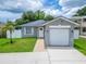 Charming single-story home featuring a well-maintained lawn, a one car garage, and freshly painted grey exterior at 719 58Th S St, Gulfport, FL 33707
