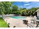 Outdoor living space showcasing a pool, travertine tile, manicured landscaping, and comfortable seating area for relaxation at 719 58Th S St, Gulfport, FL 33707